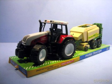 Traktor z prasą pod kloszem.